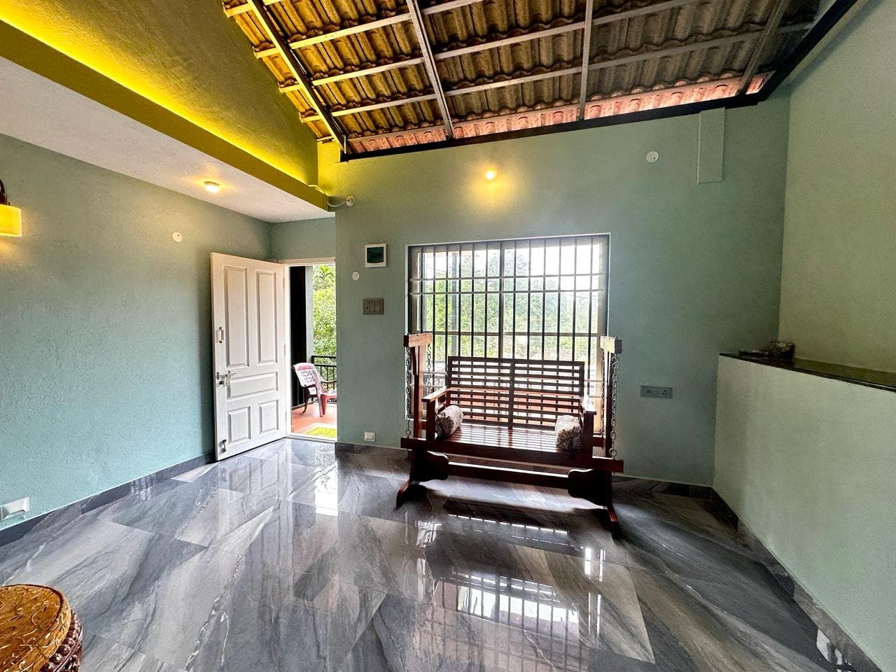 Living area with a wooden swing seat beside a window